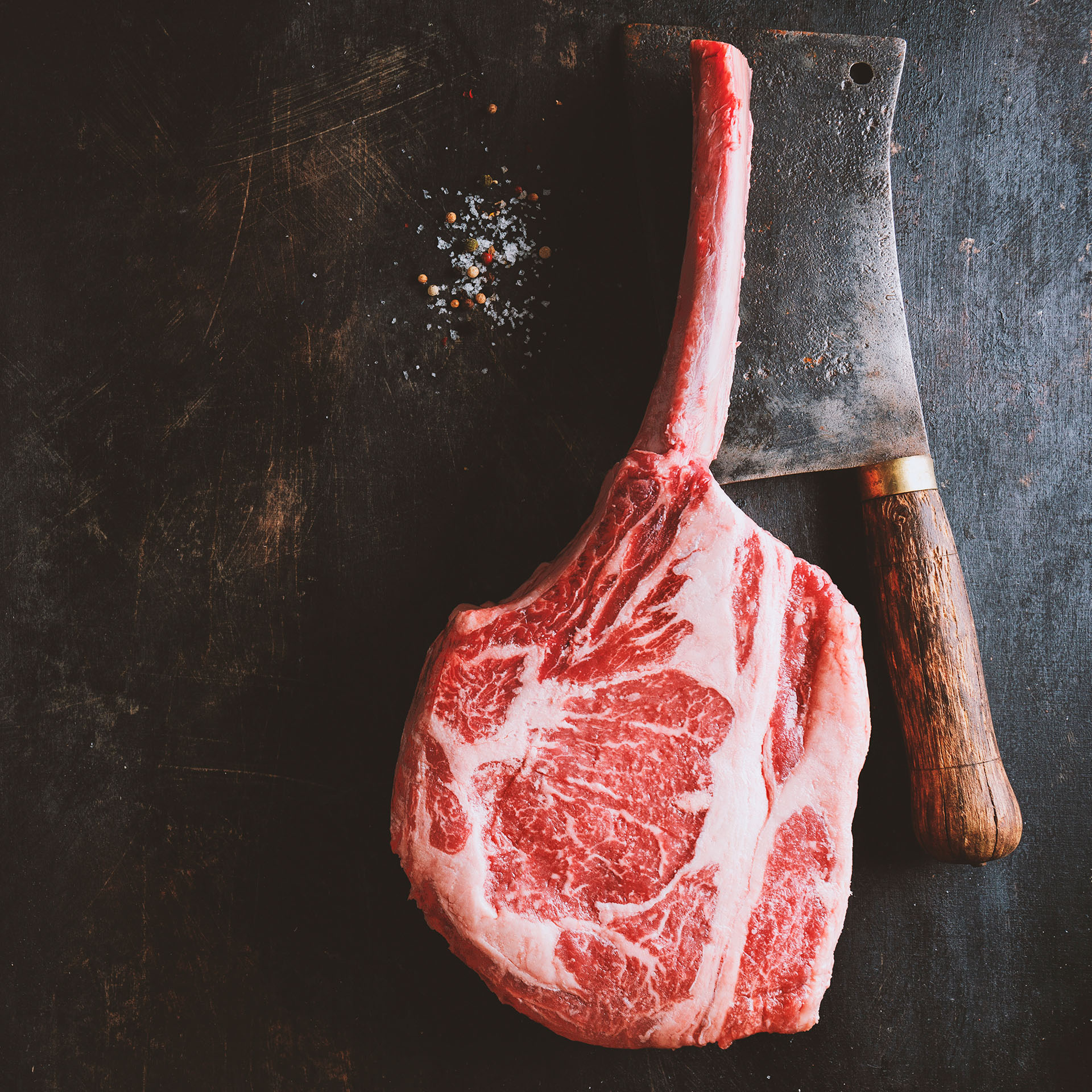 Trozo de costillar, junto a un cuchillo de carnicero